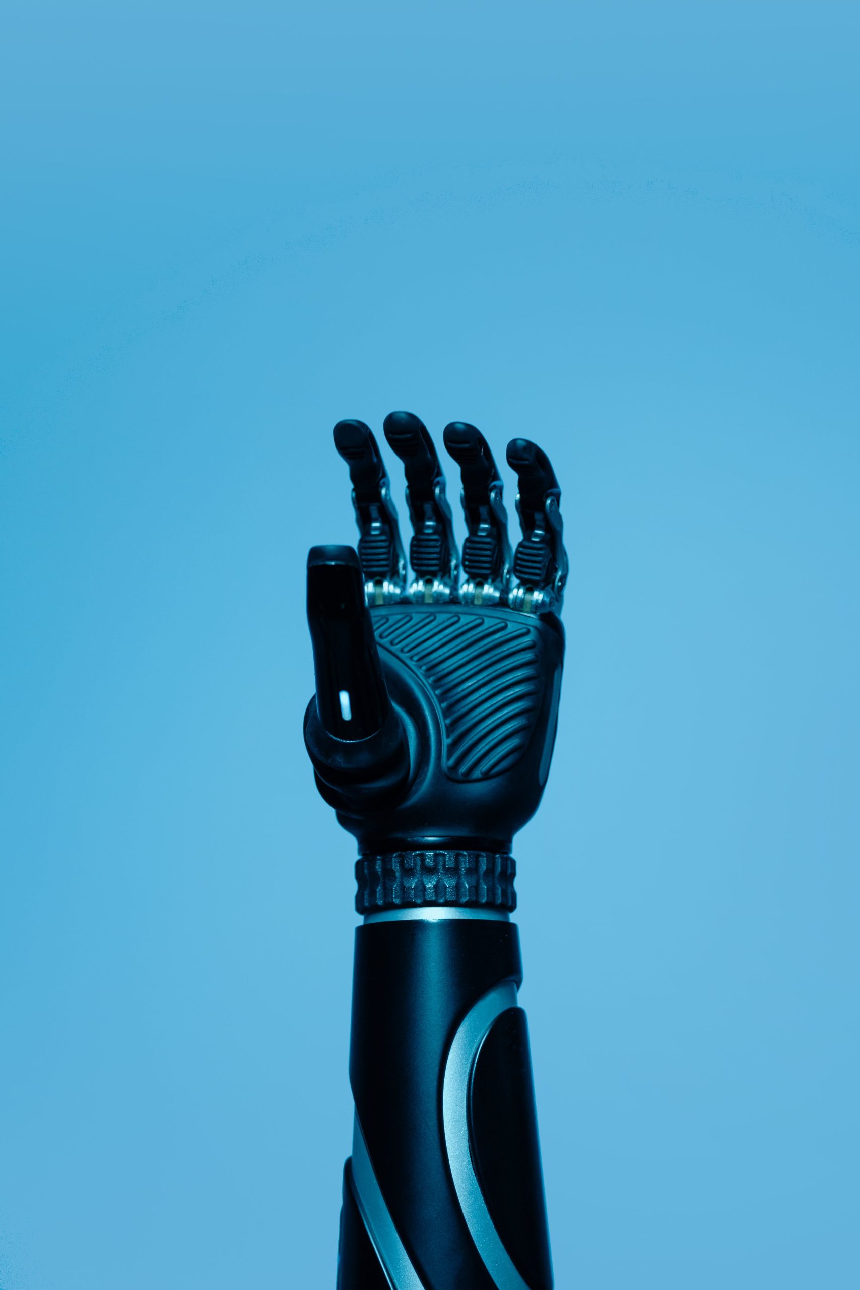 A high-tech robotic prosthetic arm reaching upwards on a blue background, symbolizing innovation in biotechnology.